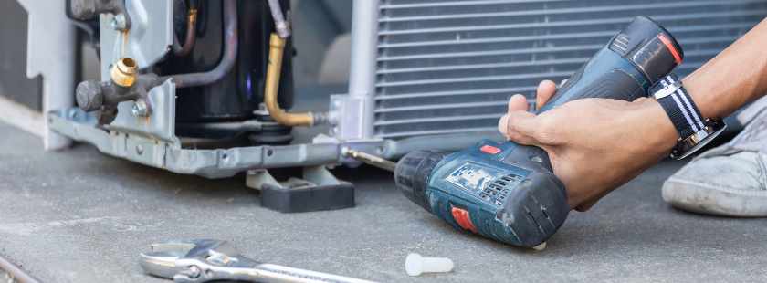 Man performing a full HVAC system replacement, installing the new unit
