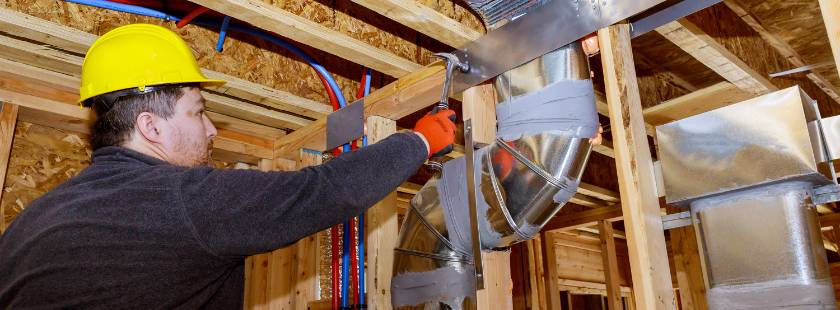 Attic Man Tech installing HVAC ductwork in a new home